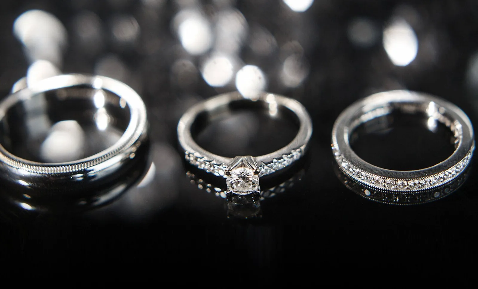 Three diamond rings on black glass